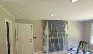 Surface Prep & Protection - Covering floors and masking the stone fireplace to ensure clean lines and a dust-free workspace.