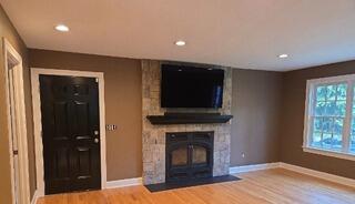 Updated wall colors, refinished trim, and a black accent door that perfectly complement the natural stone fireplace.
