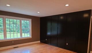 The finished dark accent wall adds striking contrast, depth, and sophisticated style to the living room.