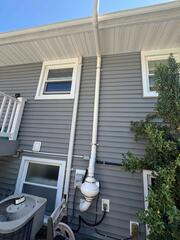 Completed exterior radon piping routed from the home toward the rear.