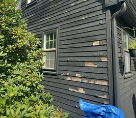 Severe paint peeling and weathered wood siding requiring professional restoration.