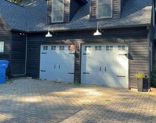 Complete exterior home transformation featuring immaculate black siding and refreshed garage accents.