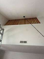 Custom wood stud framing installed inside a high ceiling wall opening for structural support.