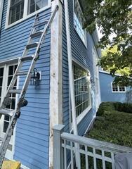 Removing damaged, rotted corner trim down to the exposed wood structure during prep work.