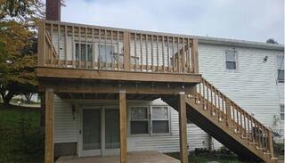 Cleaned and prepped raw wood structure of a two-story deck, ready for full protective stain application.