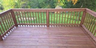 Flawless, uniform stain finish applied across upper walkways and staircase entries to maximize durability and curb appeal.