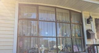 Before: Faded, weathered dark trim surrounding the front bay window needed surface preparation.