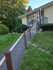 Complete exterior transformation featuring freshly painted porch railings, walkway posts, and front entryway.