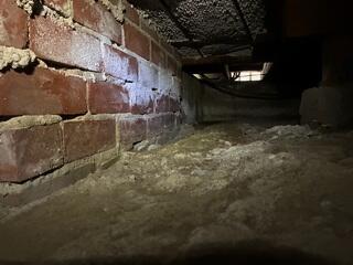 Exposed Masonry and Soil Before Crawl Space Encapsulation