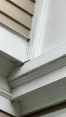 Before repair: Cracking seams, failed caulking, and water penetration risks along upper exterior trim