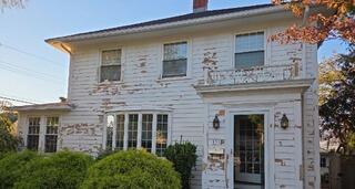 Worn out and peeling exterior wood siding on the back elevation needing full surface prep and repainting