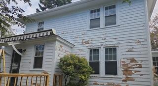 Severe paint peeling and weather damage on front facade siding diminishing home curb appeal