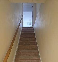 Before: Plain beige stairwell entryway needing fresh coat painting and wall prep work