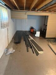 In this photo you can see the pieces of our drainage system that would be installed along the walls of the basement. This collects water seeping through the joint of the wall and floor, instead sending it to the sump pump.