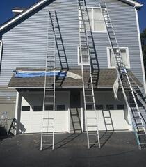 Safely reaching high-peaked gables with professional ladder setups for thorough prep work above the garage.