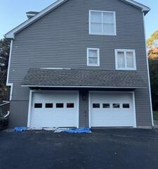 Beautifully restored exterior siding and crisp white garage trim following a full professional coating application.