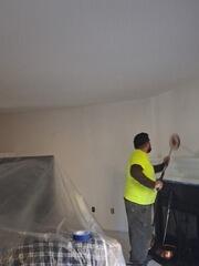 Applying a fresh, seamless coat of high-grade ceiling paint using professional roller extensions