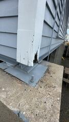 Severe wood decay and water damage exposed at the base of a structural support column.