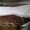 Every wall of the crawl space is covered. Once the vapor barrier is fastened to the walls and sealed, the crew begins work on sealing off the floor as well.