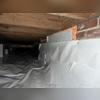 Here is an area of the crawl space after debris was removed and the encapsulation was installed. Note the Foamax insulative barrier installed where there was a crawl space opening.