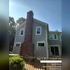 Side of home showing brick chimney and deck railings