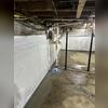 A bright, clean CleanSpace wall liner being installed to provide a vapor barrier and improve the appearance of the basement.