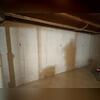 The basement wall is bowing in and also dealing with humidity. These needs to be addressed before the problem worsens over time.