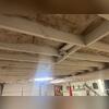 This photo shows signs of structural stress in the home's floor system. The added support beam suggests the original joists were sagging or failing, likely causing uneven floors above. The aged insulation and sealed wood indicate past moisture issues, which can lead to musty odors, mold, and poor...