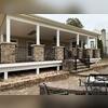 A wide-angle look at the left side of this North Star, DE covered deck shows off the stone-wrapped columns and sleek black Trex Signature railings. Built with Trex Transcend decking, this structure offers both durability and modern elegance.