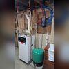 The green tank on the floor is the expansion tank. As the water in the system heats up on a cold day, it expands into this tank. When the system shuts off and the water cools, the tank pushes the water back into the system. Simple but cool.