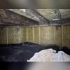 Visible signs of moisture damage and dark staining on the wooden beams show why this crawl space needed professional moisture control.