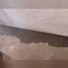 The crew leaves a 3/8in gap between the wall and the floor to ensure water seepage drains.