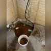 As soon as there was no sump pump the water was rising quickly. It appears reddish orange due to the iron ochre. Installers placed a temporary pump into it so that it wouldn't flood the basement.