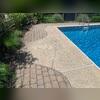 This homeowner's concrete pool deck began to settle due to persistent moisture intrusion and shifting soil beneath the slabs, which created voids and caused the concrete to sink over time.