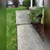 Uneven slabs around this front entryway sidewalk were caused by moisture intrusion and poorly compressed fill soil beneath the concrete, leading to gradual settlement and instability over time.
