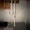 A precisely positioned vent pipe along the home's exterior directs radon safely away from the unfinished basement.