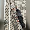 Securing radon gas vent pipe to home.