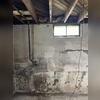 One wall in this basement began to bow outward from pressure. As the wall bowed out, cracks began to form, and water started to leak through them and into the basement.