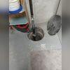 Any lid on a sump pump which is not sealed to the slab is not airtight. The lid to the right in this photo has a slot to allow it to be put in place around the discharge line. Other than preventing some objects from falling in, it servers very little purpose.