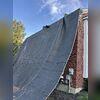Tarps were placed around the home to protect siding and landscaping during tear-off.