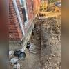 To install our helical piers into stable, load-bearing soil, we first expose the home's footing. Once the piers are drilled down, we secure them to the underside of the footing using our "L"-shaped brackets, which latch firmly beneath the foundation for a strong, permanent connection.