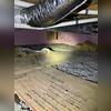 This crawl space shows damp floors and insulation in need of replacement.