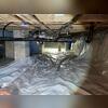 This crawl space shows damp floors and insulation in need of replacement.