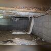 This crawl space shows damp floors and insulation in need of replacement.