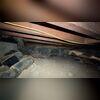 This crawl space shows damp floors and insulation in need of replacement.