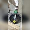 Sump pit in a Colorado Springs home, sealed and prepped for radon mitigation, tucked behind a false bedroom wall with limited clearance.