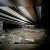 This crawl space shows damp, uneven ground and failing insulation that needs attention.