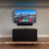 Wall-mounted television and soundbar paired with custom AV cabinetry for clean integration and concealed components.