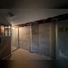 During installation of the PowerBrace Wall Stabilization System, steel beams are positioned vertically along the basement wall to address cracking and inward movement. Each beam is securely anchored to the basement floor and framing above to provide long-term structural stabilization.