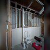 Exterior PVC piping installed to safely vent radon gas from beneath the home to above the roofline.
